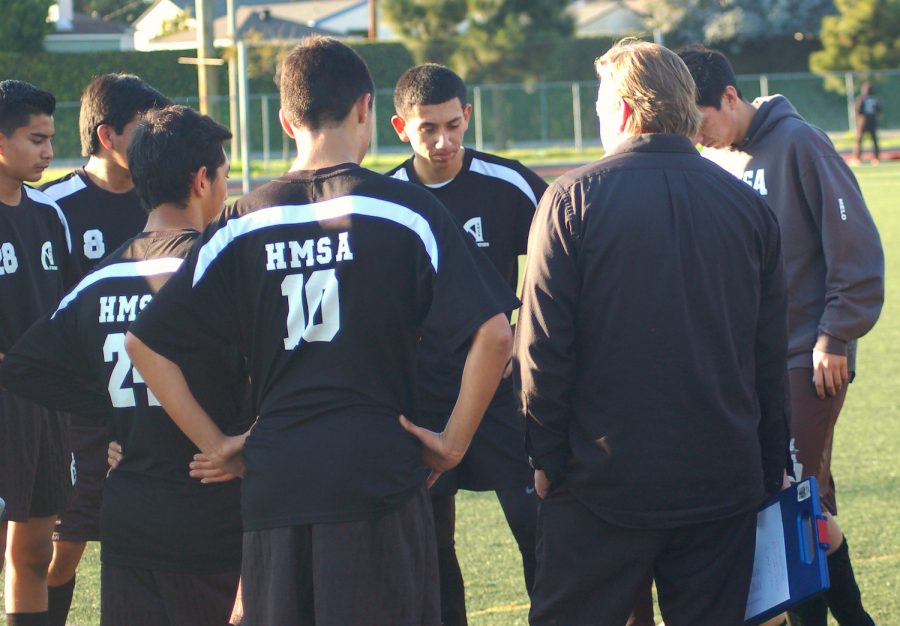 HMSAs boys soccer coach, Mr. Lanuis gathers with a few players before the game. (Photo by Fortune S.)